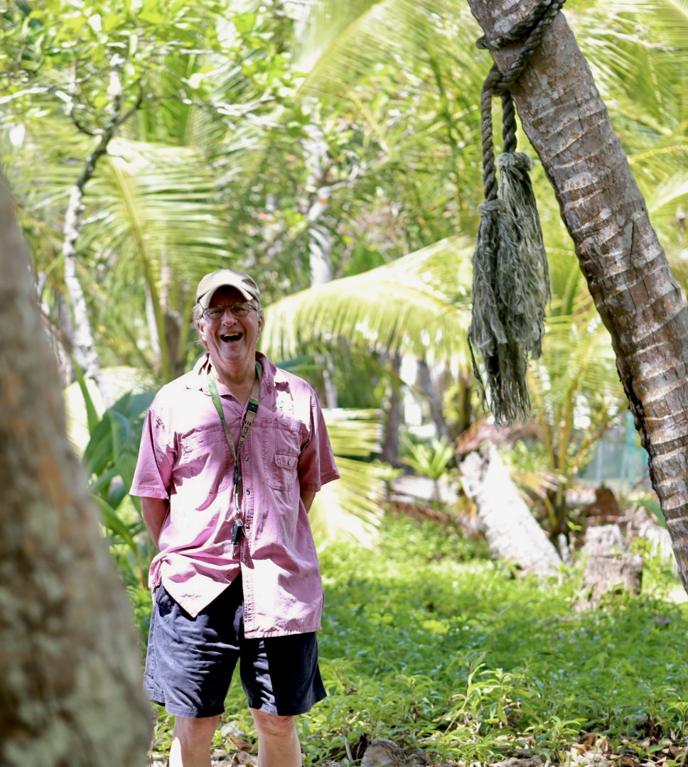 JP 'Joe' Carson smiling among palm trees